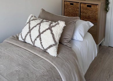 Comfortable bed setup at Sarah Lawson Beauty, Dalkeith, Scotland, GB featuring plush pillows and soft blankets.