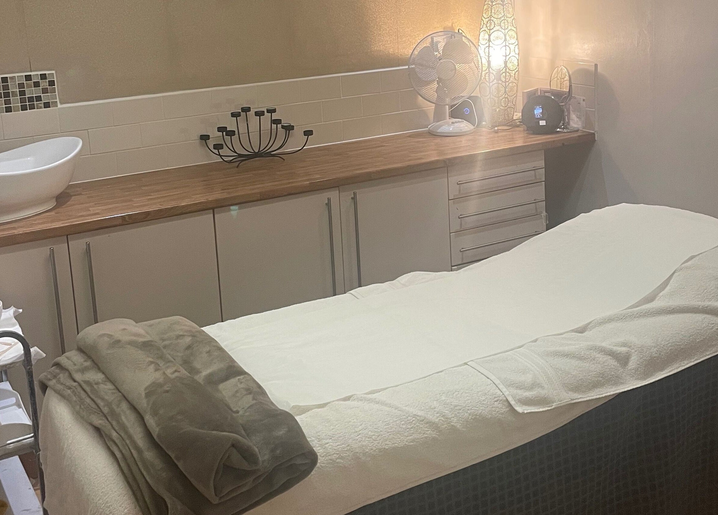 Relaxing treatment room at Beautevas Beauty and Tanning, Martlesham, England, GB with cozy decor.