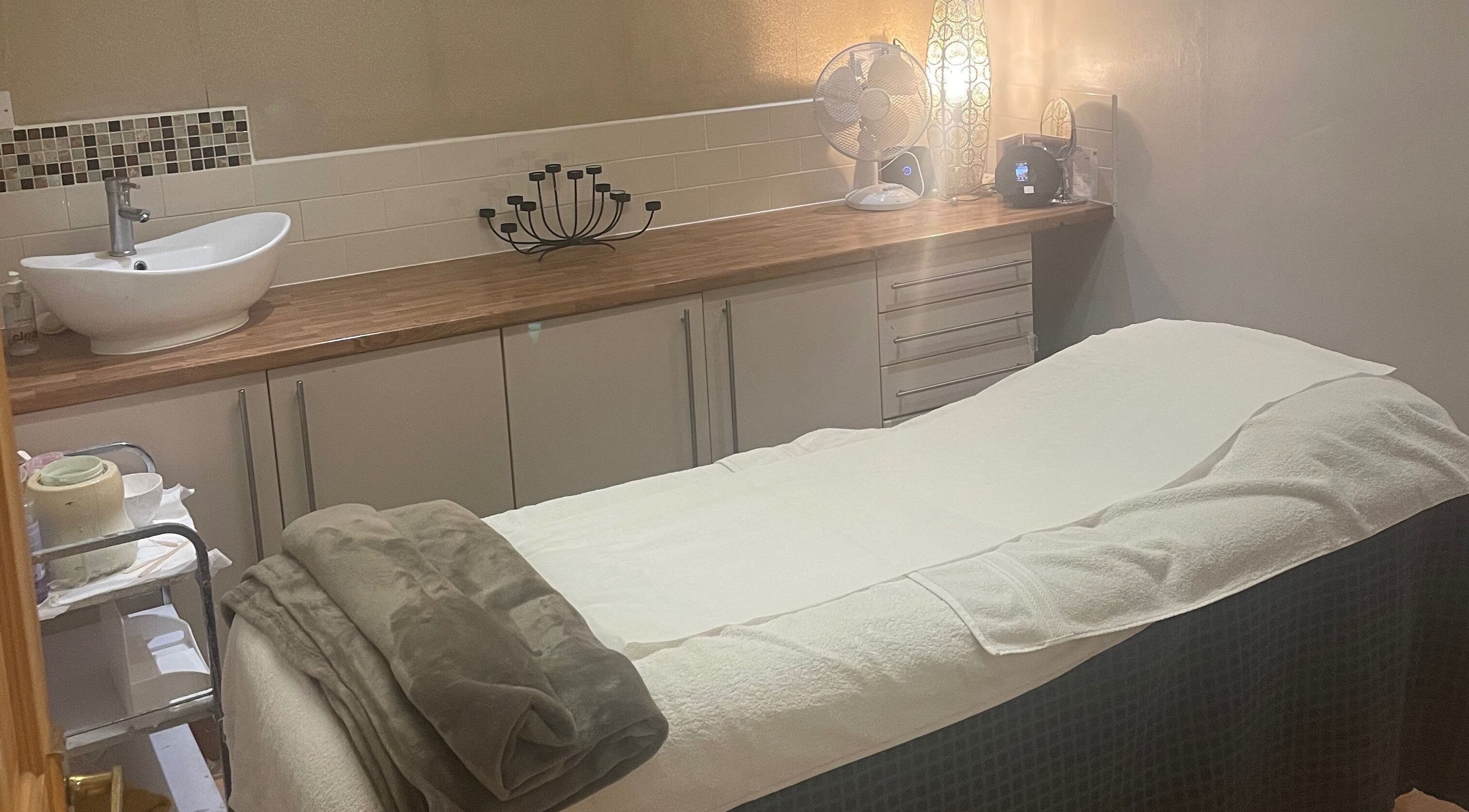 Relaxing treatment room at Beautevas Beauty and Tanning, Martlesham, England, GB with cozy decor.