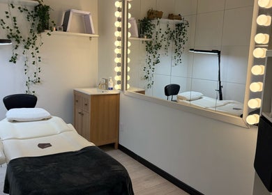 Salle de soins apaisante chez Renüa Medspa, Mascouche, Québec, CA avec table de massage et miroir lumineux.