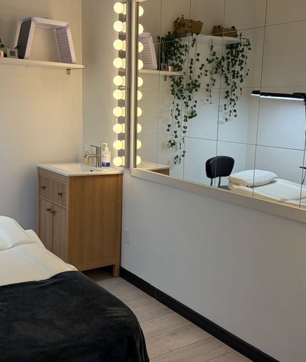 Salle de soins élégante chez Renüa Medspa à Mascouche, Quebec, CA, décorée avec des plantes et un miroir lumineux.