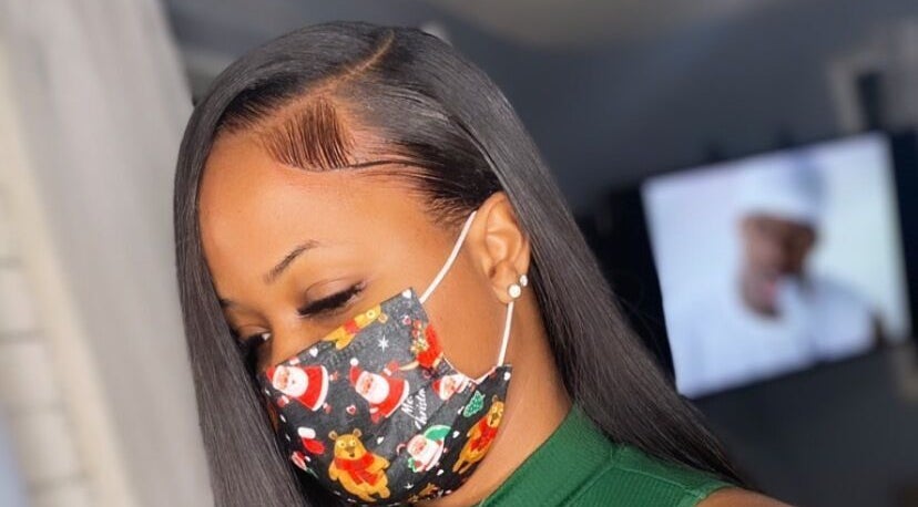 Elegant woman with sleek hairstyle at Justslay Beauty Crib, Ellerton, Saint George, BB, wearing a festive mask.