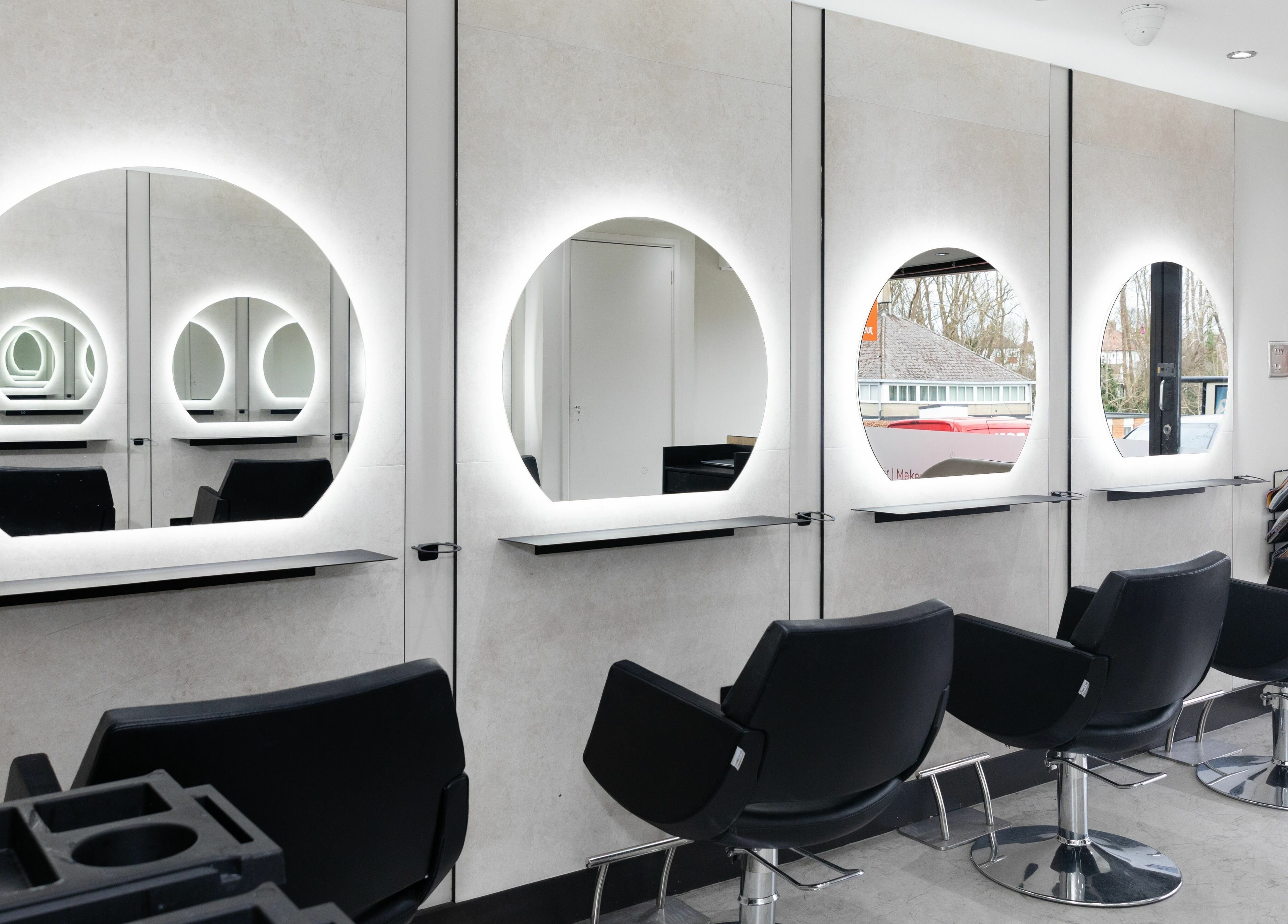 Modern salon interior at Elizabeth May Studios, Orpington, England, GB with stylish mirrors and chairs.