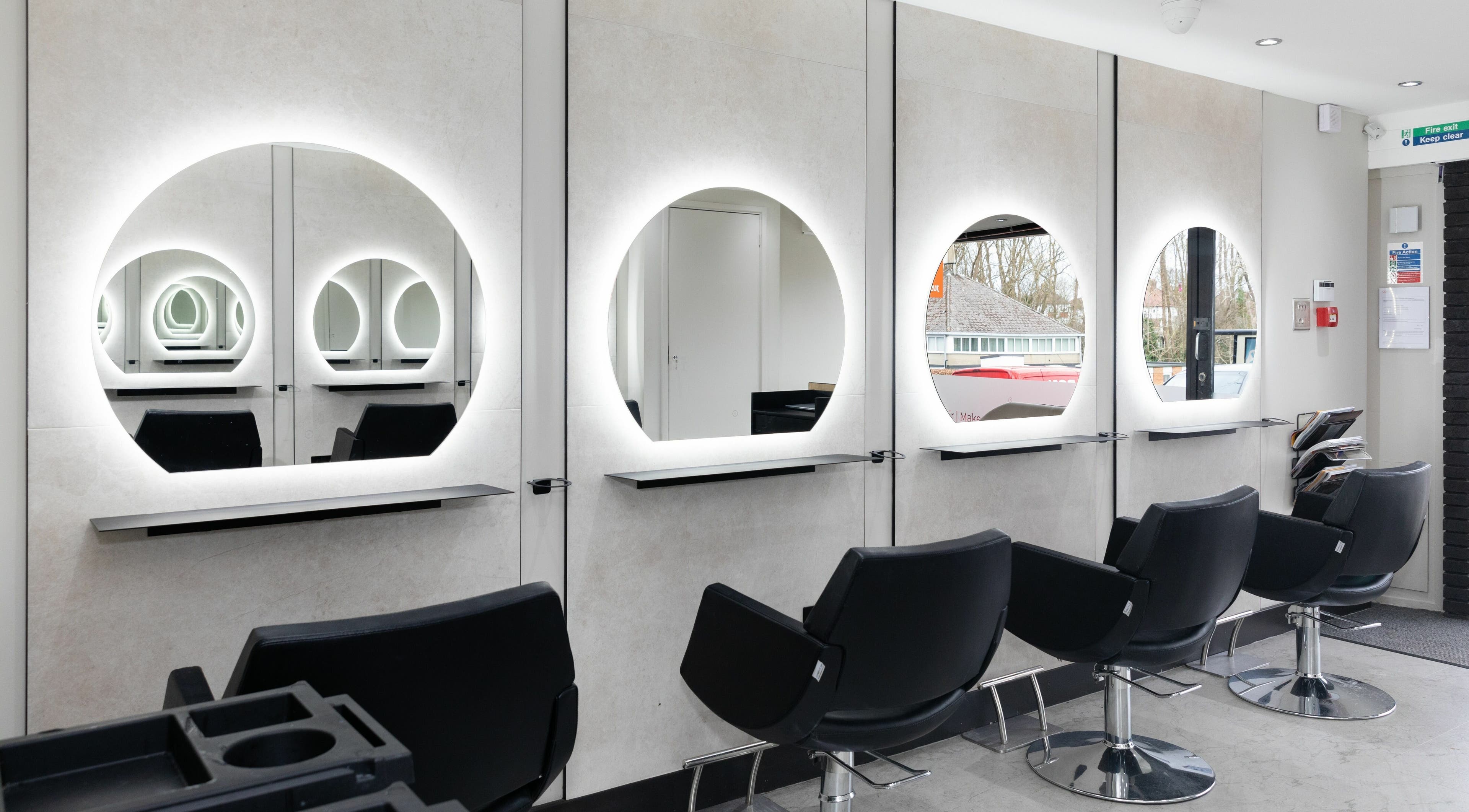 Modern salon interior at Elizabeth May Studios, Orpington, England, GB with stylish mirrors and chairs.