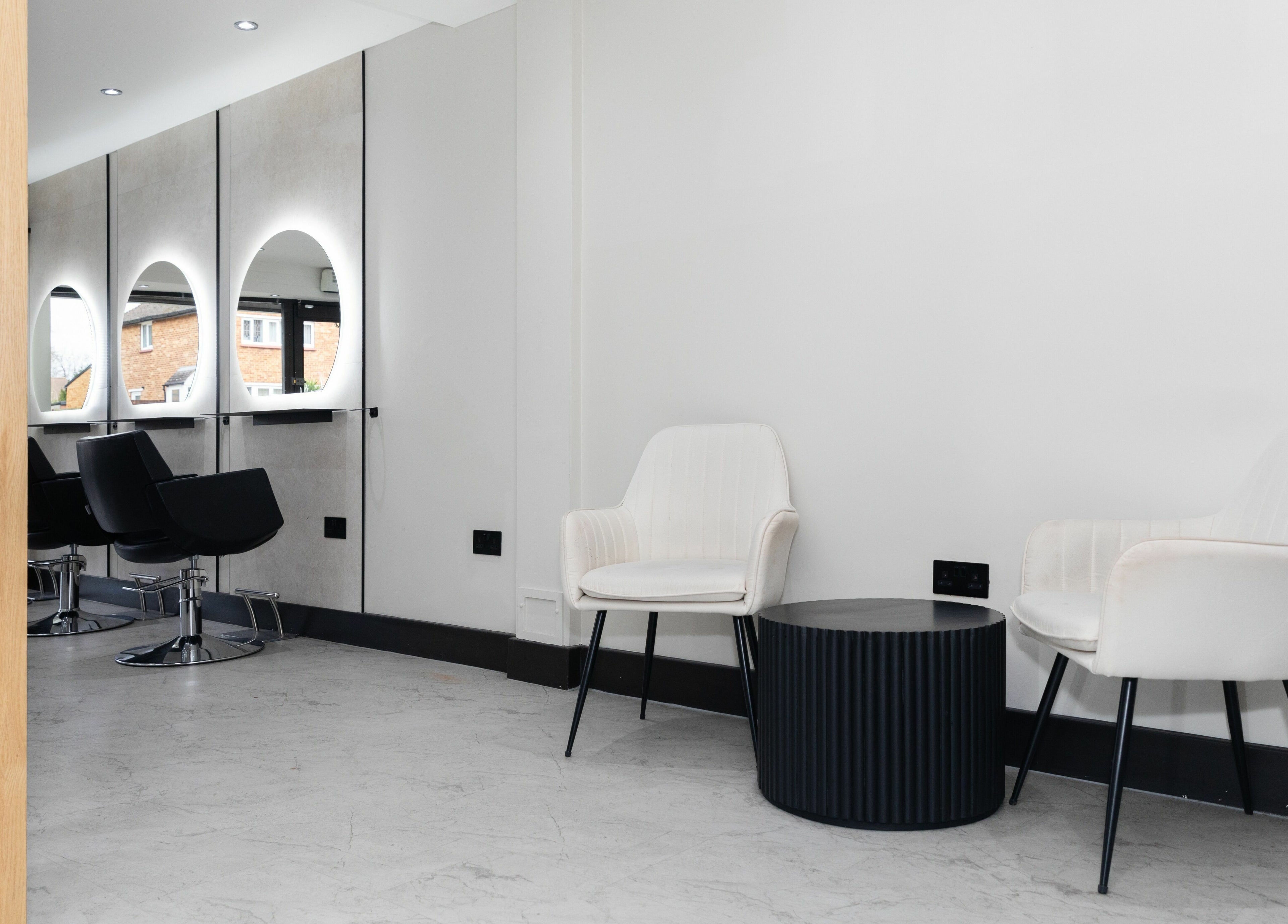 Modern beauty salon interior at Elizabeth May Studios, Orpington, England, GB, featuring sleek chairs and mirrors.