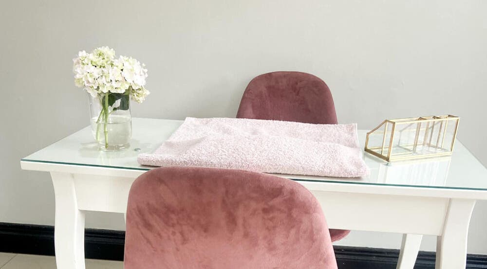Plush pink chairs and fresh flowers at JB Beauty Studio, Pretoria, Gauteng, ZA for serene spa experiences.