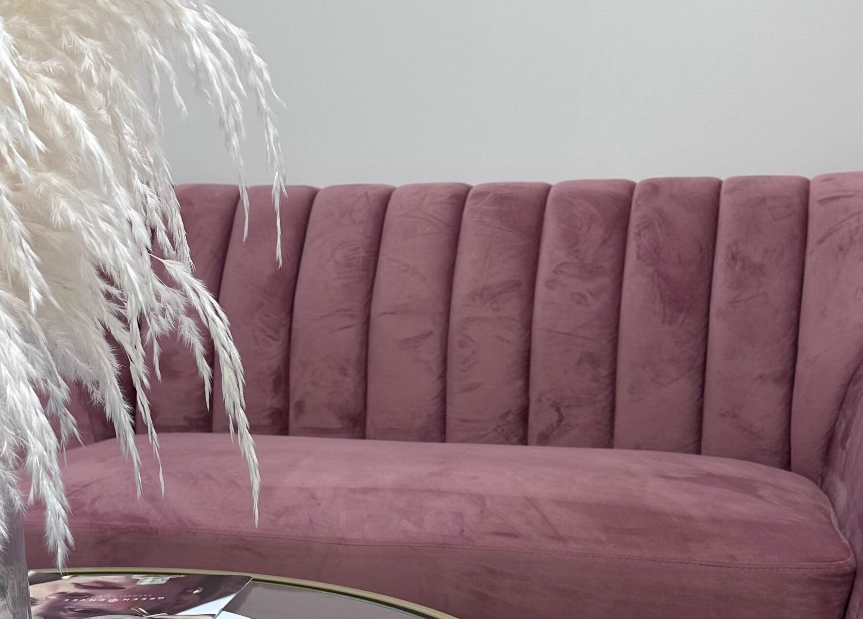 Elegant pink sofa at Pretty Hurts, Leduc, Alberta, CA, accentuated by soft pampas grass decor.