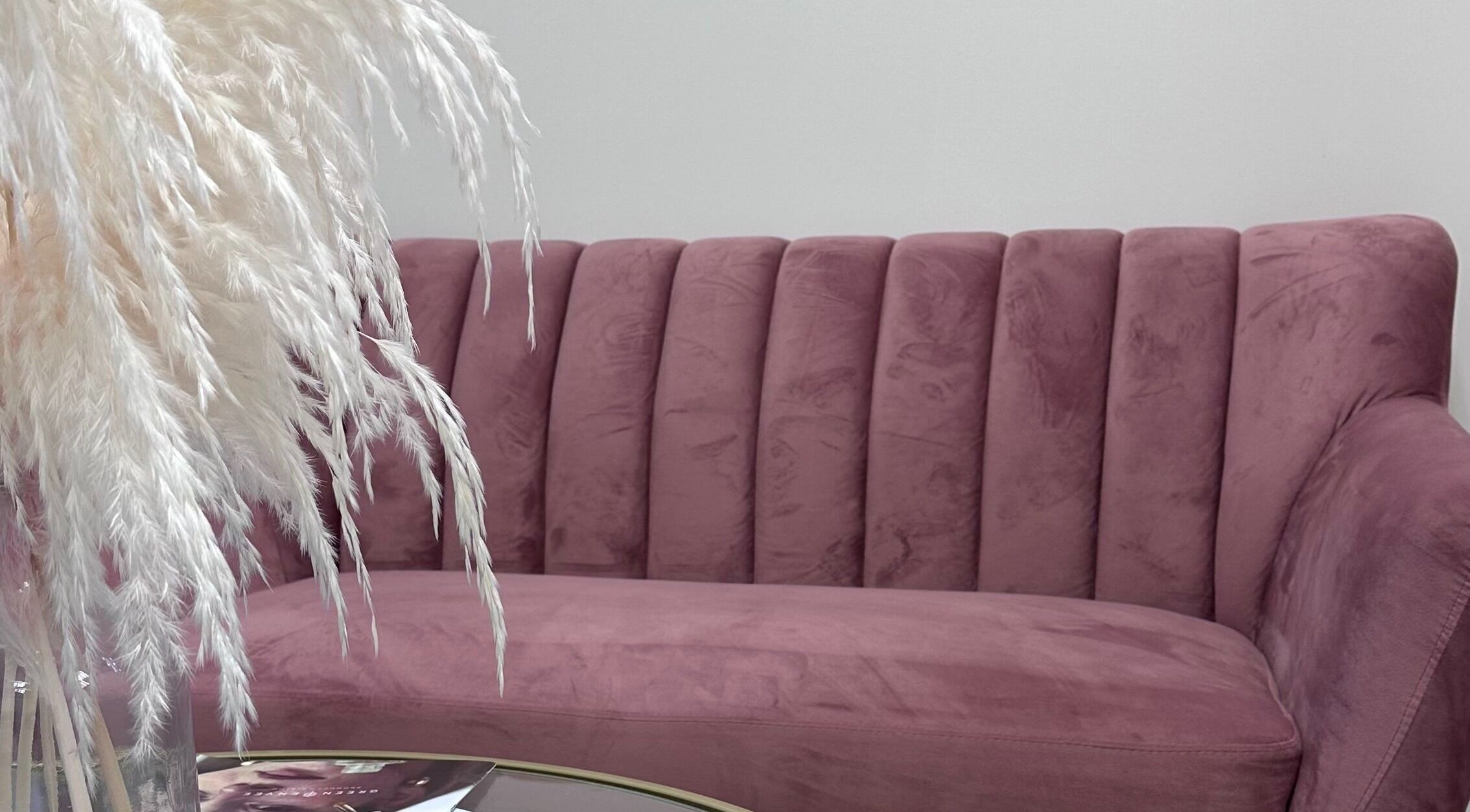 Elegant pink sofa at Pretty Hurts, Leduc, Alberta, CA, accentuated by soft pampas grass decor.