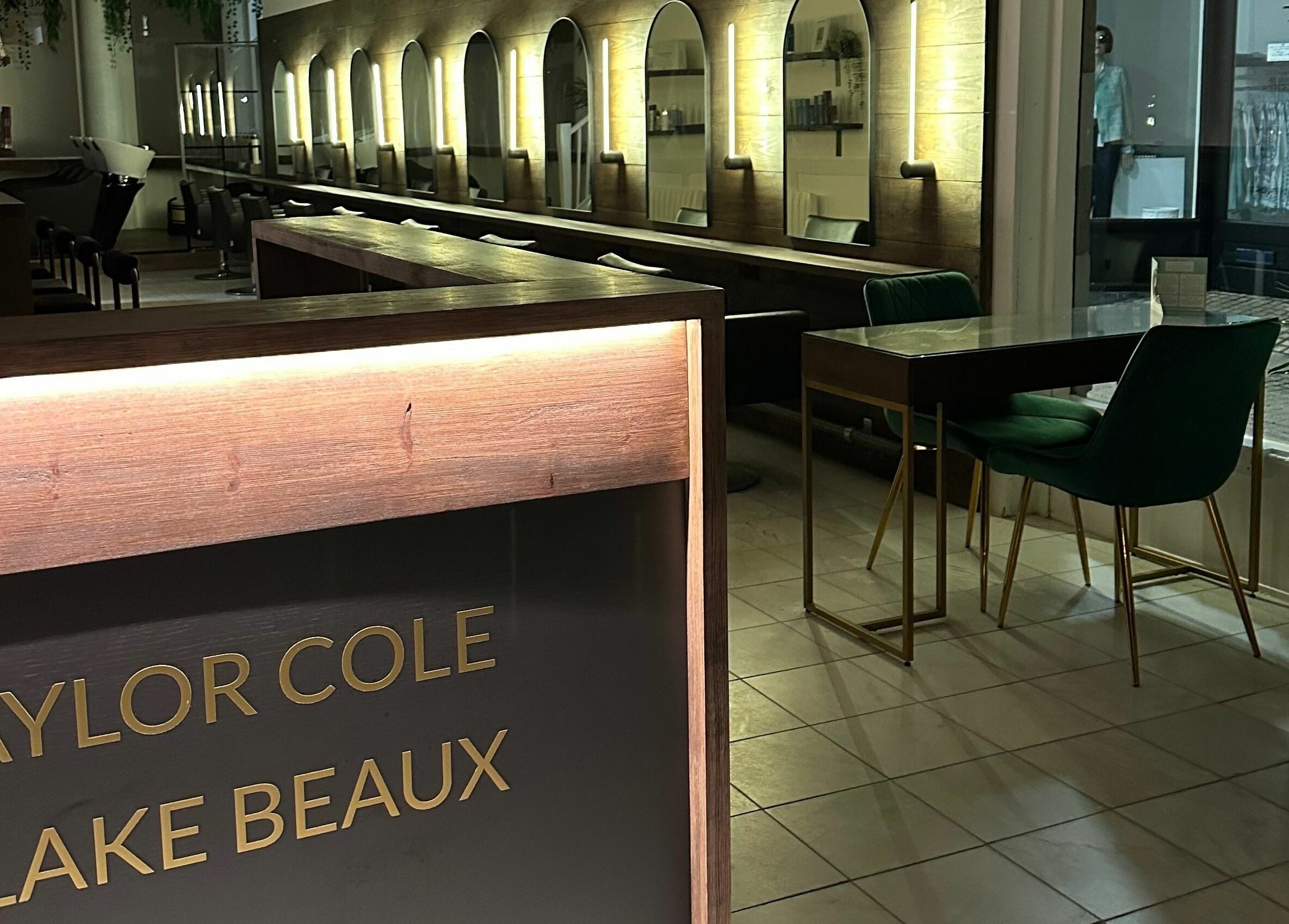 Taylor Cole salon in Truro, England, GB. Chic lighting, green chairs, and wood accents create a sleek and modern look.