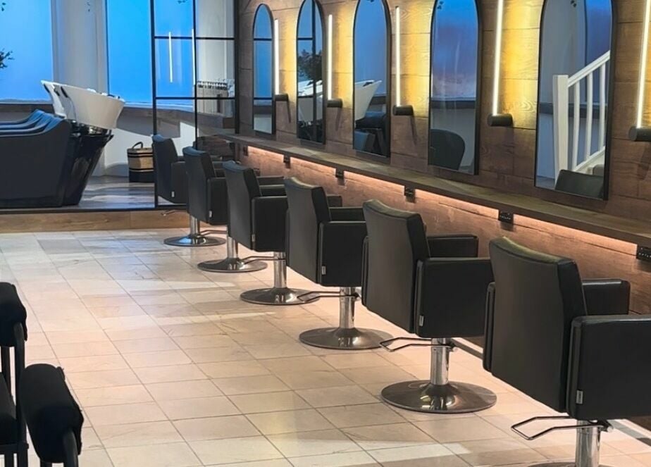 Elegant salon interior at Taylor Cole, Truro, England, GB with modern styling chairs and mirrors.