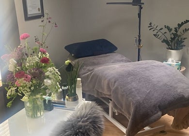 Cozy treatment room at Sparrow Beauty Co., Nelson, BC, featuring a comfy bed and fresh flowers.