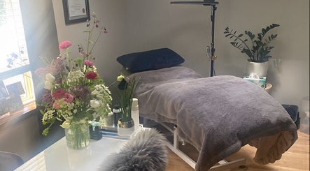 Cozy treatment room at Sparrow Beauty Co., Nelson, BC, featuring a comfy bed and fresh flowers.