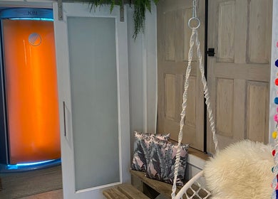 Relaxing spa room at Sparrow Beauty Co. in Nelson, British Columbia, CA with vibrant decor and a swing chair.