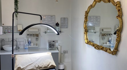 Elegant treatment room at Coco Aesthetics & Beauty in Coal Aston, England, GB featuring a gold ornate mirror.