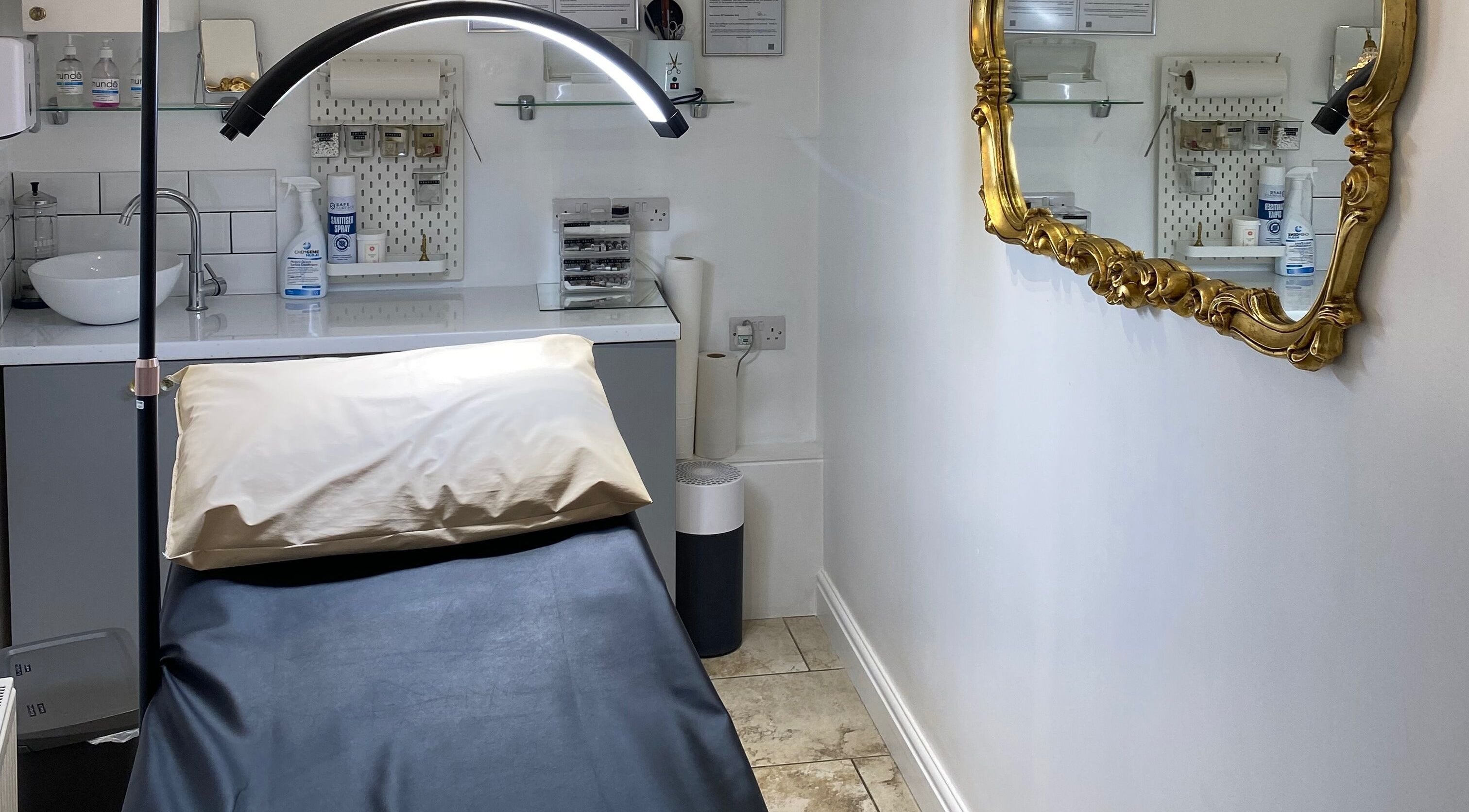 Treatment room at Coco Aesthetics & Beauty in Coal Aston, England, GB featuring a golden mirror and modern decor.