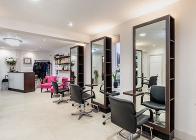 Modern salon interior at Emava, Solihull, England, GB, featuring stylish chairs and mirrors.