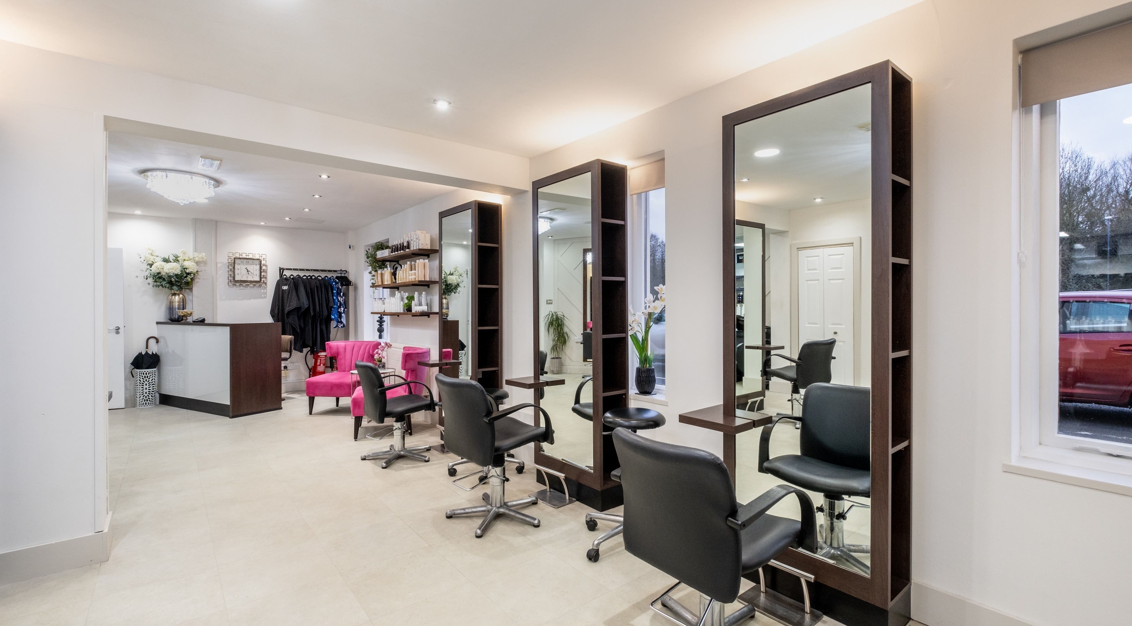Modern salon interior at Emava, Solihull, England, GB, featuring stylish chairs and mirrors.