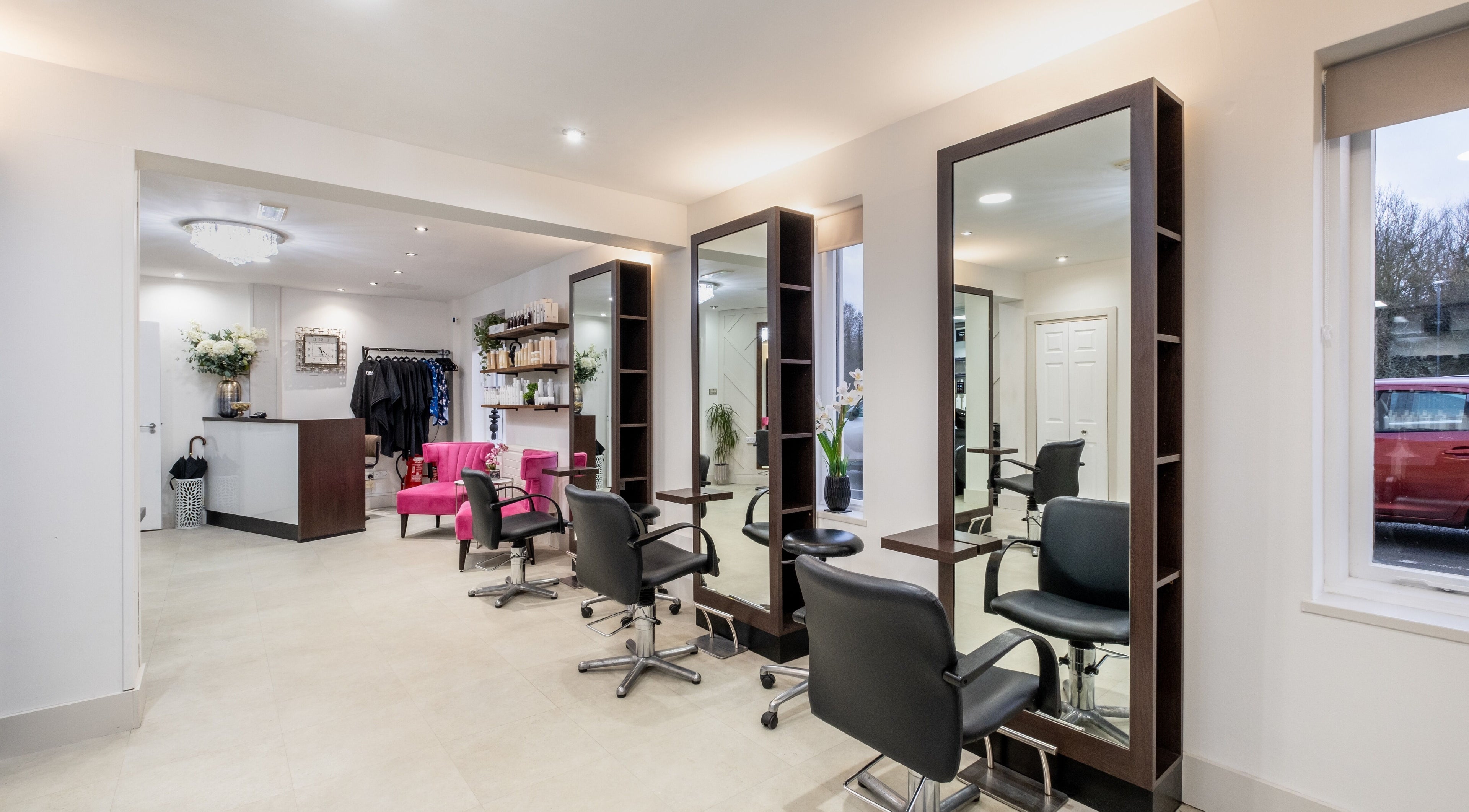 Modern salon interior at Emava, Solihull, England, GB, featuring stylish chairs and mirrors.