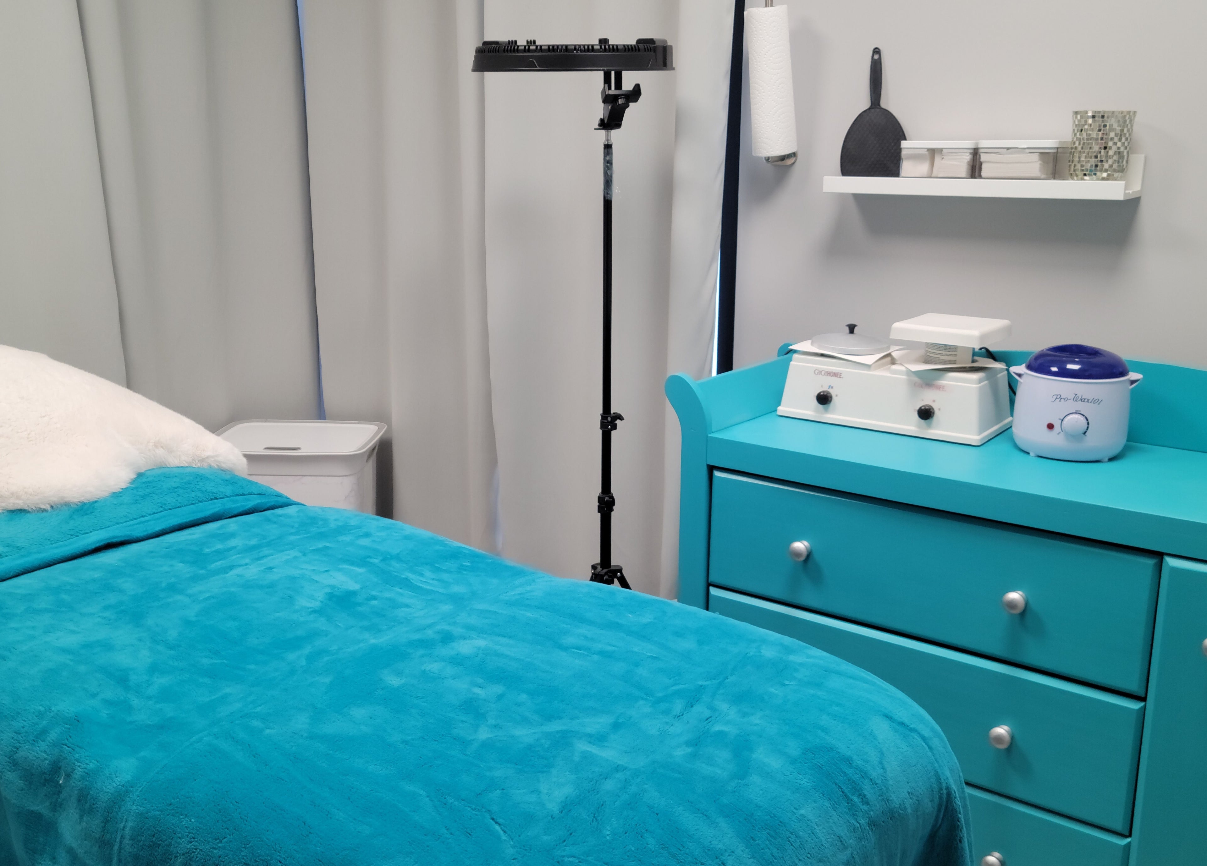 Calm treatment room at Symmetry Skin & Body in Greater Sudbury, Ontario, CA with teal decor and equipment.