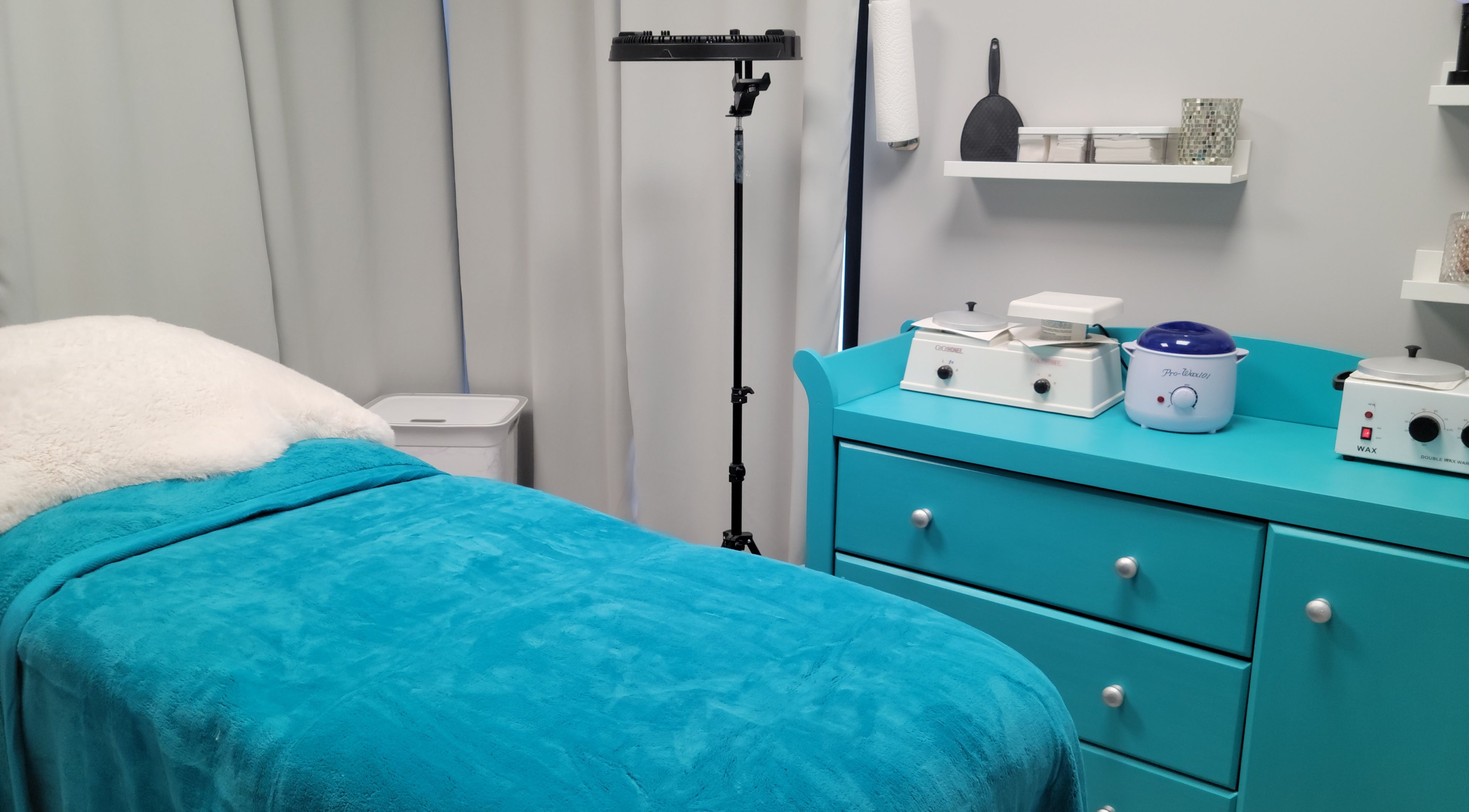 Relaxing treatment room at Symmetry Skin & Body, Greater Sudbury, Ontario, CA with teal accents and cozy bed.