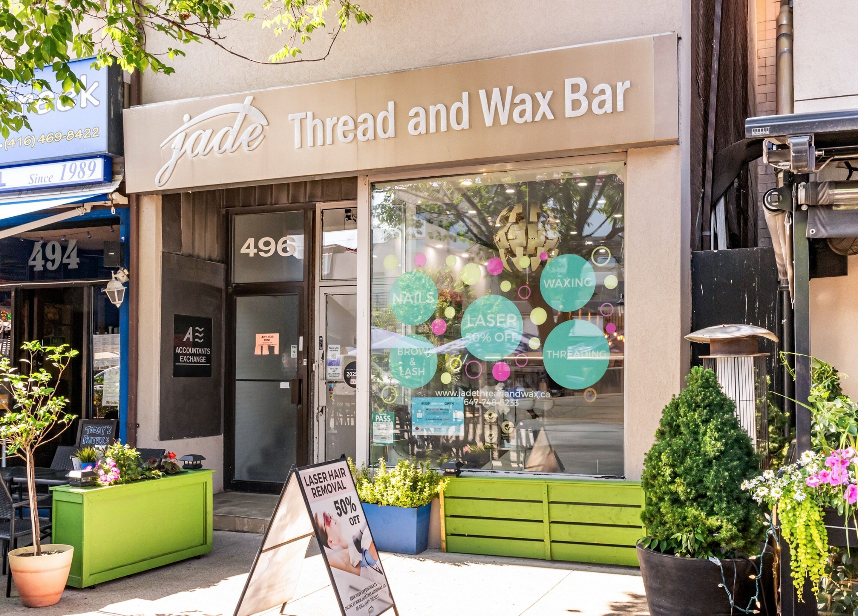 Front view of Jade Thread and Wax Bar - Danforth in Toronto, Ontario, CA with vibrant signage and plants.