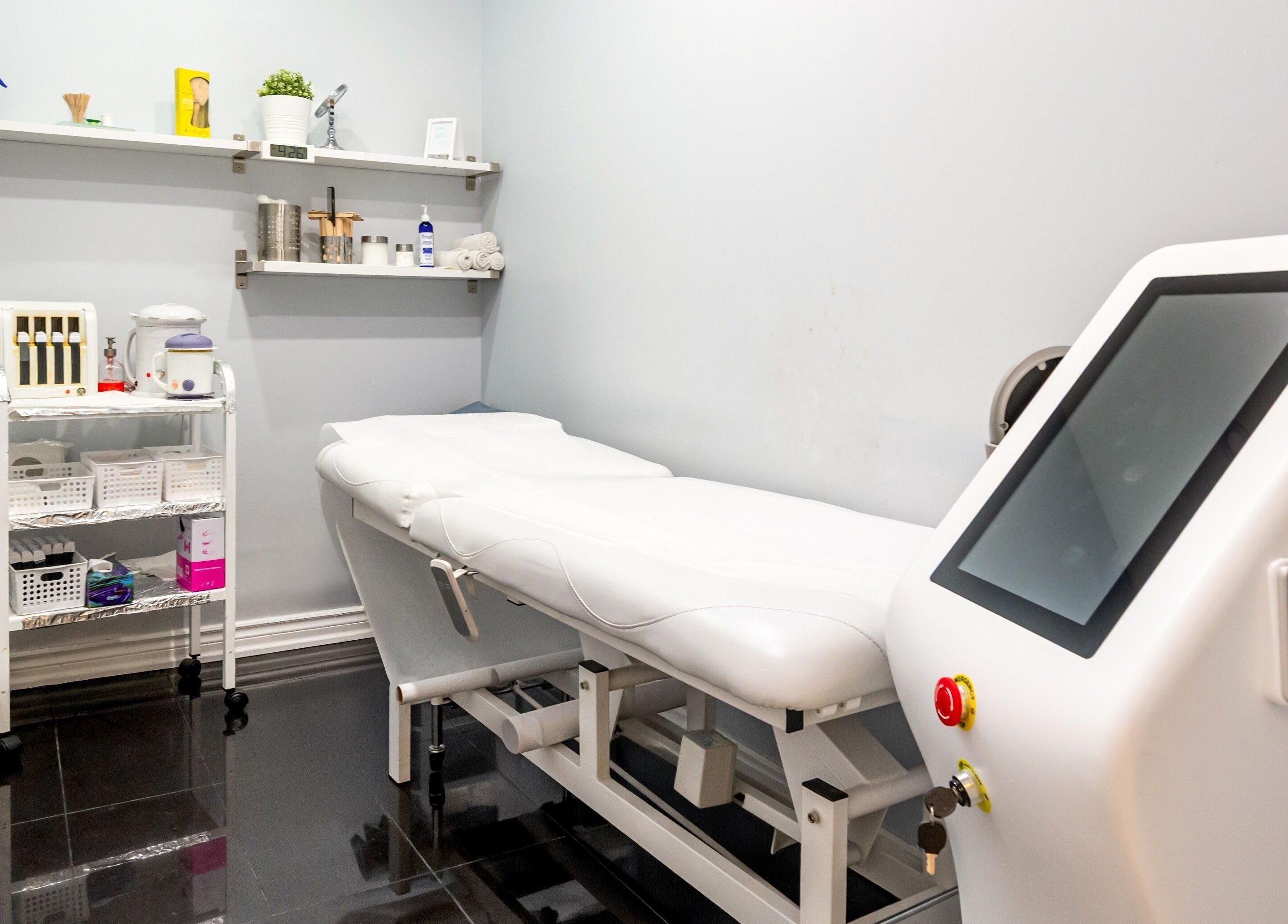 Treatment room at Jade Thread and Wax Bar - Danforth, Toronto, Ontario, CA with bed and modern equipment.