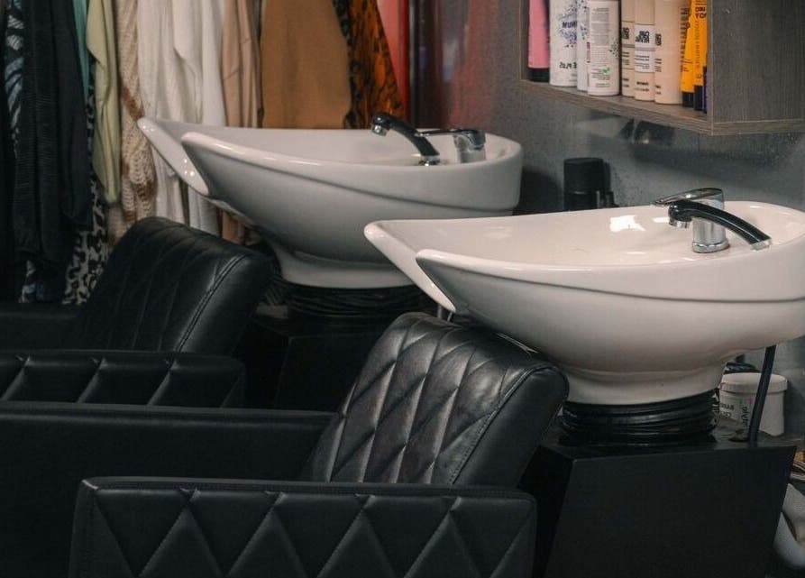 Chic wash stations at Bobby Bob's Salon & Barber Shop, Halstead, England, GB featuring black leather chairs.