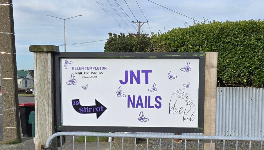 Entrance sign for JNT Nails, a nail salon in Invercargill, Southland, NZ, featuring decorative butterflies.