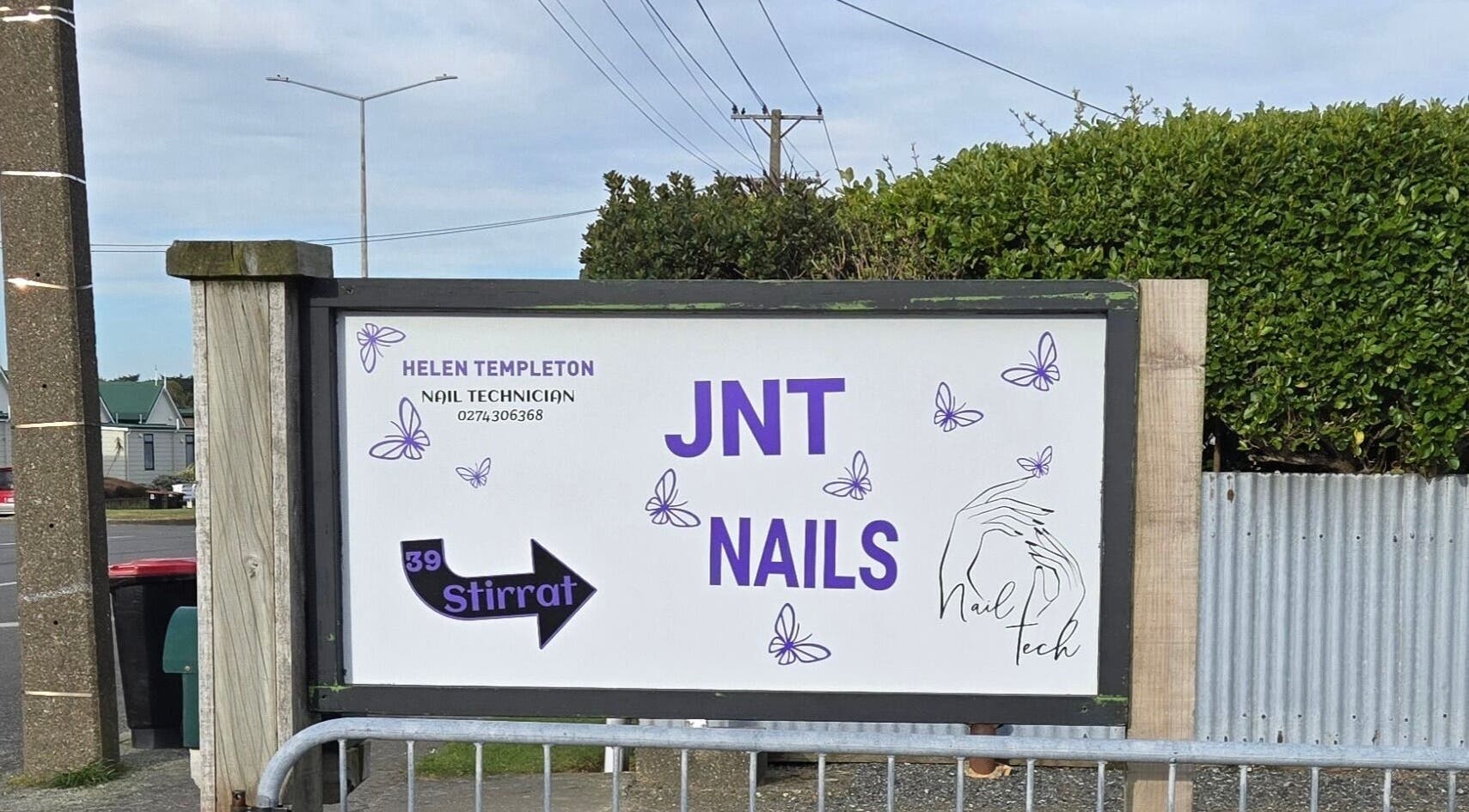 Sign for JNT Nails in Invercargill, Southland, NZ, featuring butterflies and a nail tech contact.