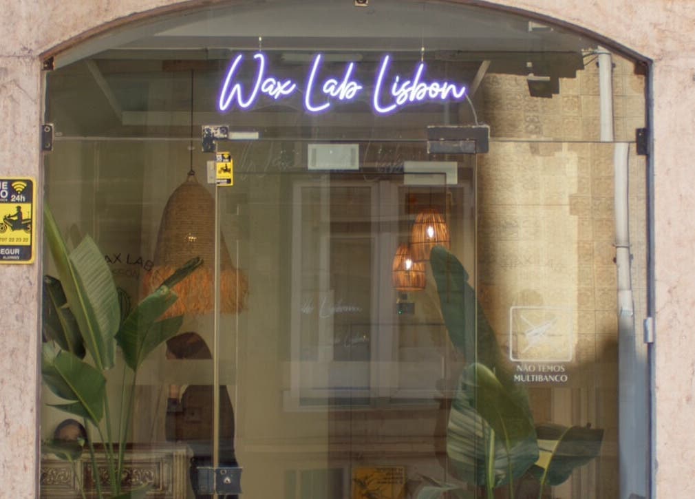 Entrance of Wax Lab Lisbon in Lisboa, Lisboa, PT with neon sign and plants.