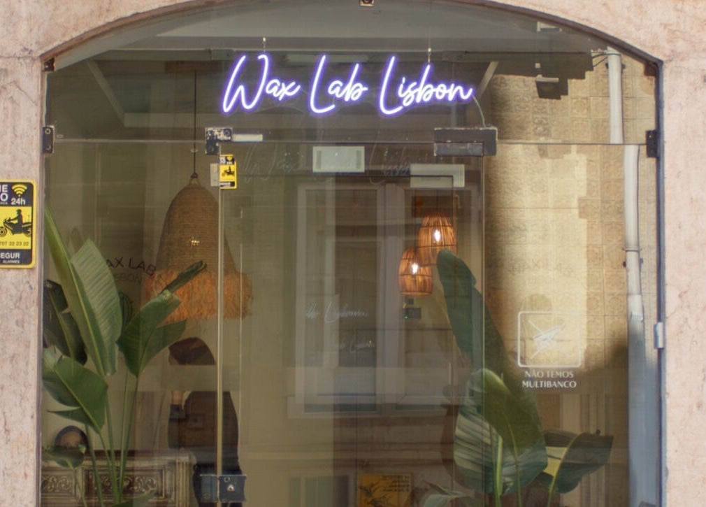 Entrance of Wax Lab Lisbon in Lisboa, Lisboa, PT with neon sign and plants.