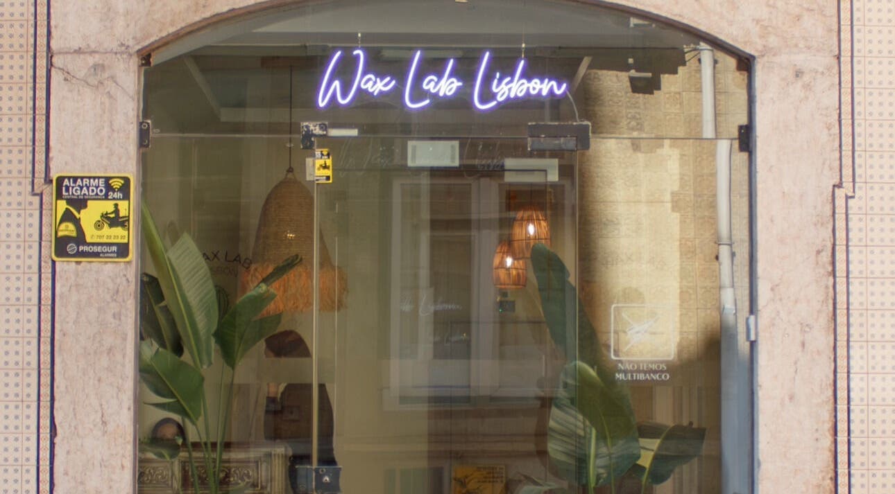 Entrance of Wax Lab Lisbon in Lisboa, Lisboa, PT with neon sign and plants.