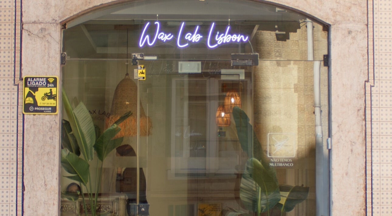Entrance of Wax Lab Lisbon in Lisboa, Lisboa, PT with neon sign and plants.