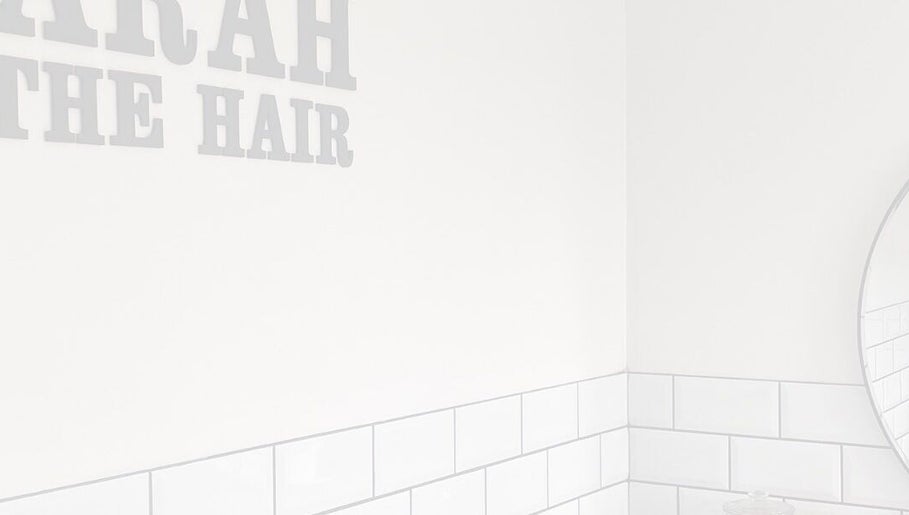 Interior corner at Sarah and the Hair, Durham, England, GB, featuring a minimalist mirror and tiled walls.