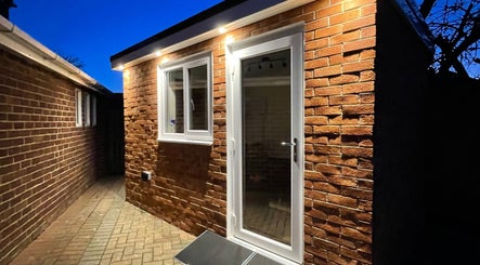 Cozy brick exterior of Sarah and the Hair, Durham, England, GB, glowing warmly at twilight.
