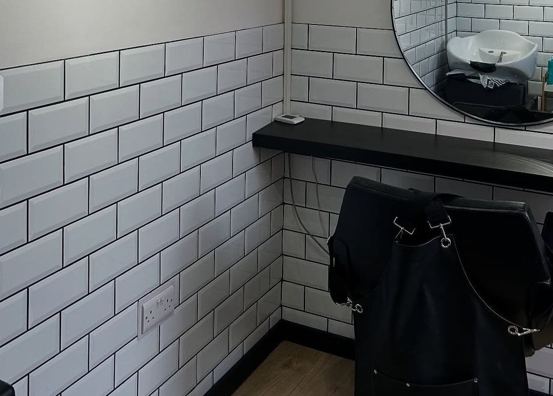 Modern hair styling area at Sarah and the Hair, Durham, England, GB with subway tiles and mirror.