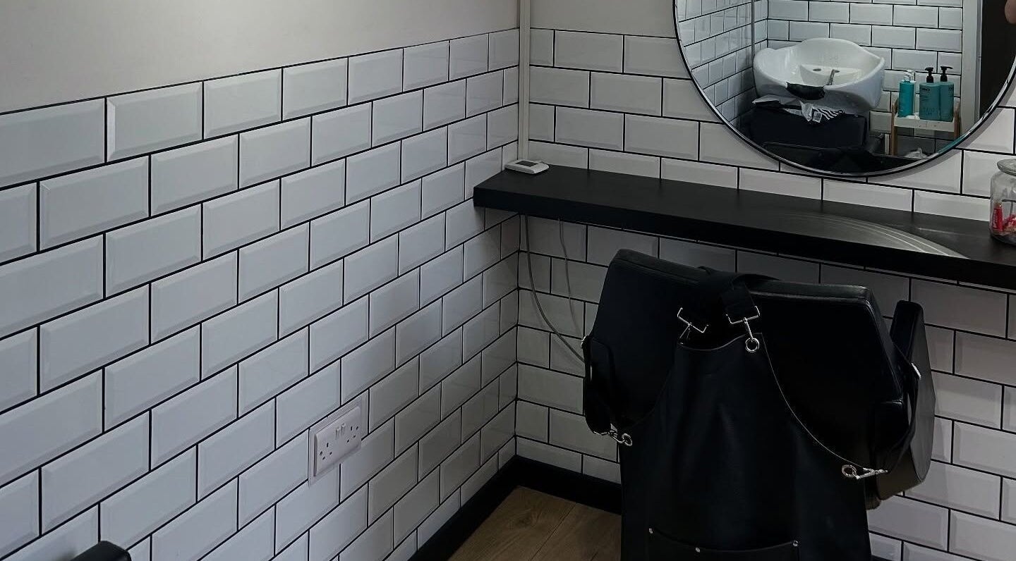 Modern hair styling area at Sarah and the Hair, Durham, England, GB with subway tiles and mirror.