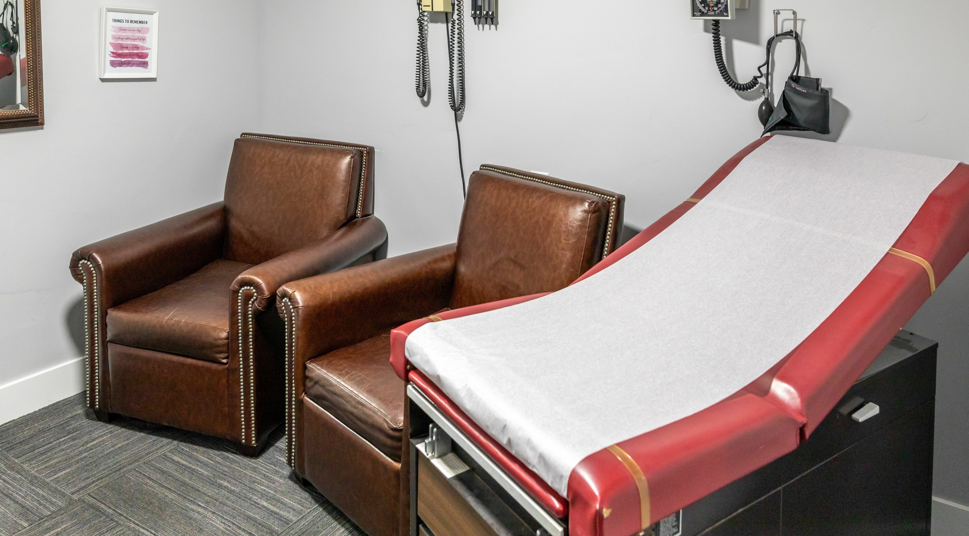 Cozy wellness treatment room at Health and Vitality in Orem, Utah, US, featuring leather chairs and a treatment table.
