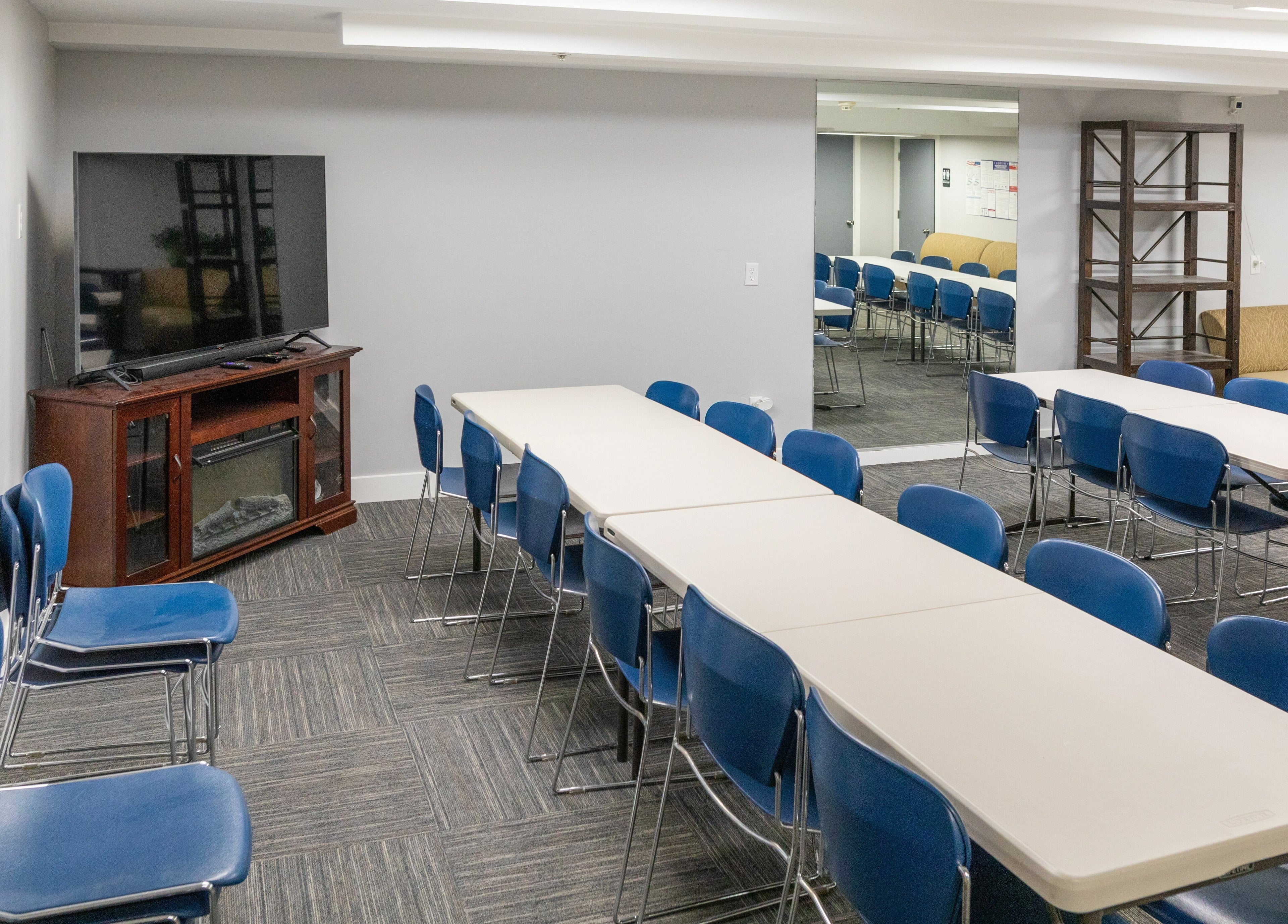 Spacious meeting room at Health and Vitality in Orem, Utah, US, featuring blue chairs and a large TV.