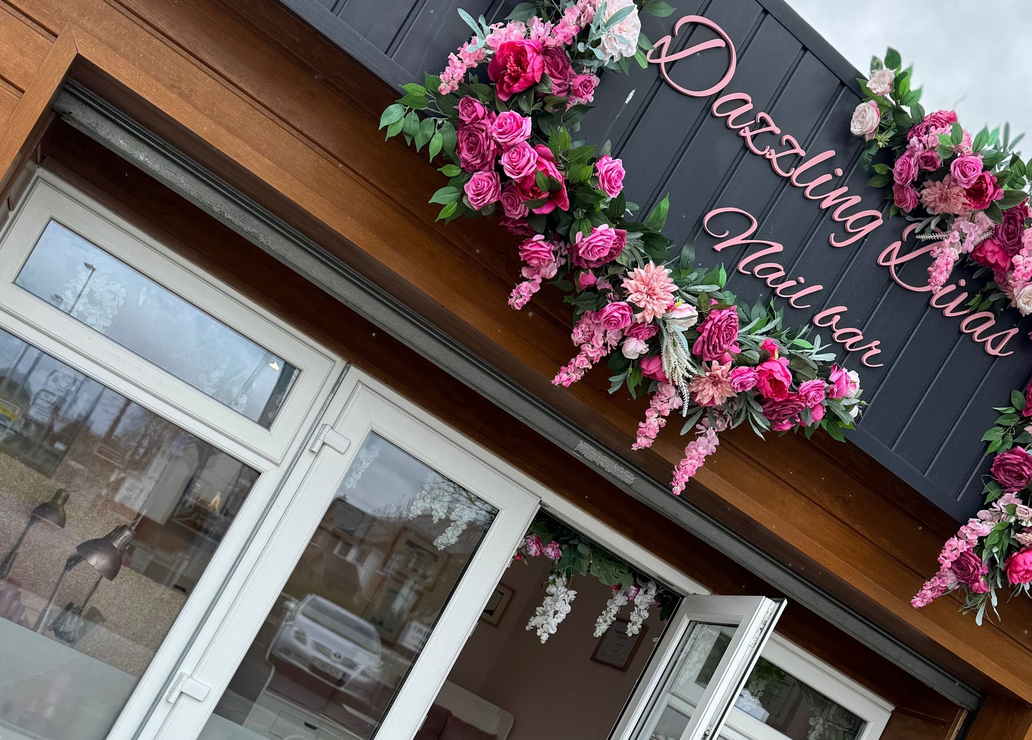 Entrance of Dazzling Diva Nails in Athenry, IE, adorned with vibrant pink floral decor.
