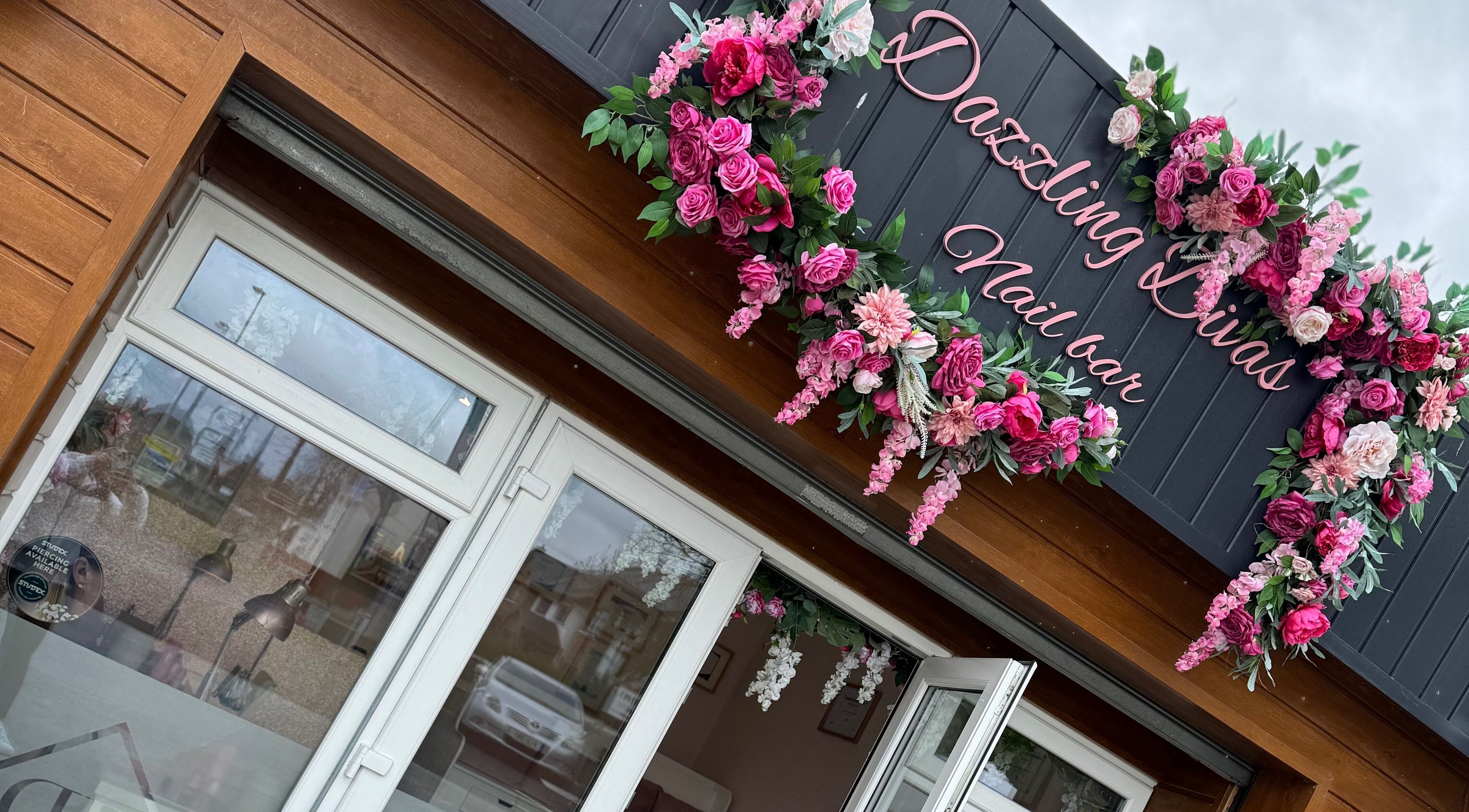 Entrance of Dazzling Diva Nails in Athenry, IE, adorned with vibrant pink floral decor.