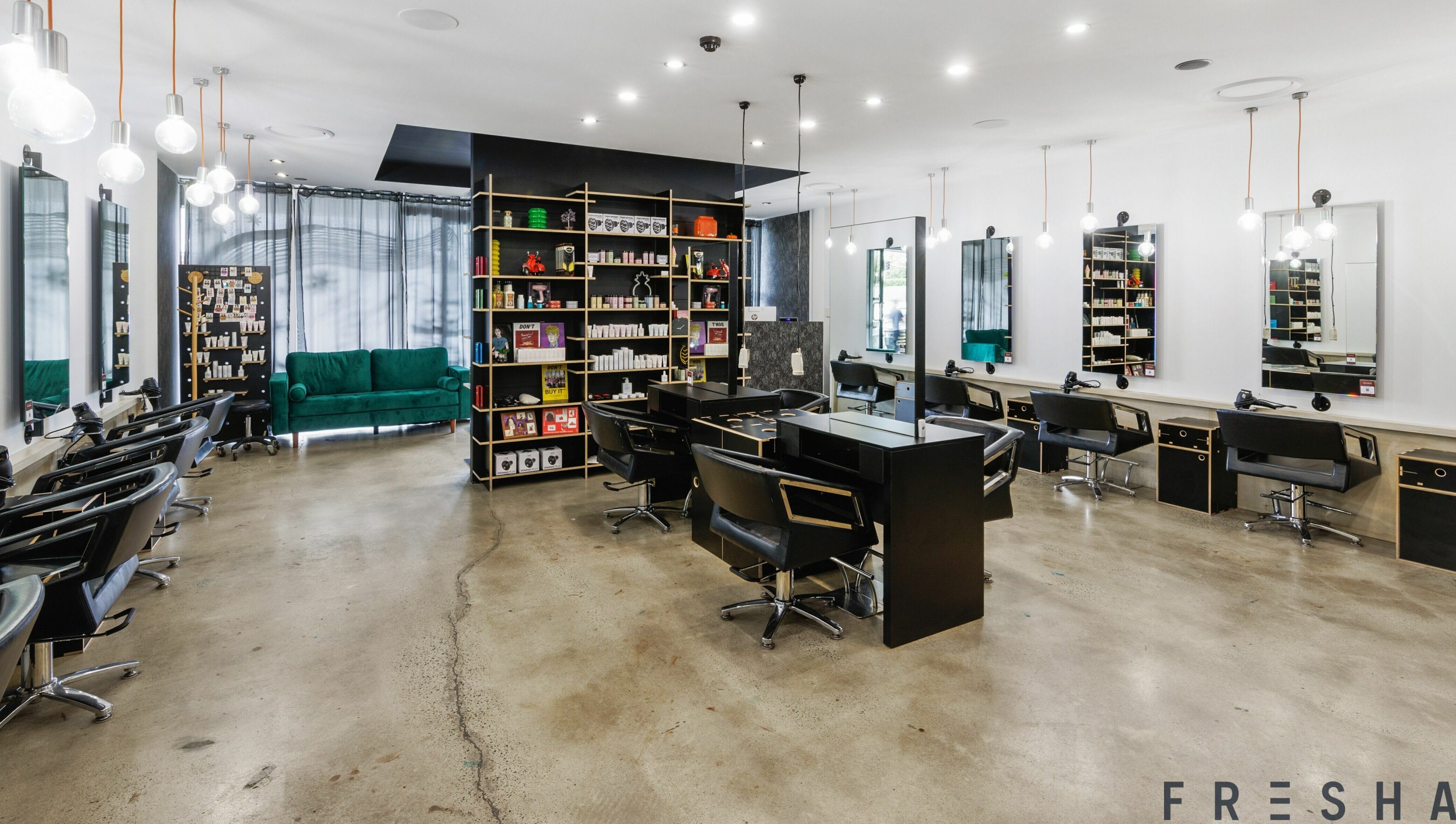 Modern salon interior of Lunatic Fringe in Clayfield, Queensland, AU with sleek styling stations and vibrant decor.