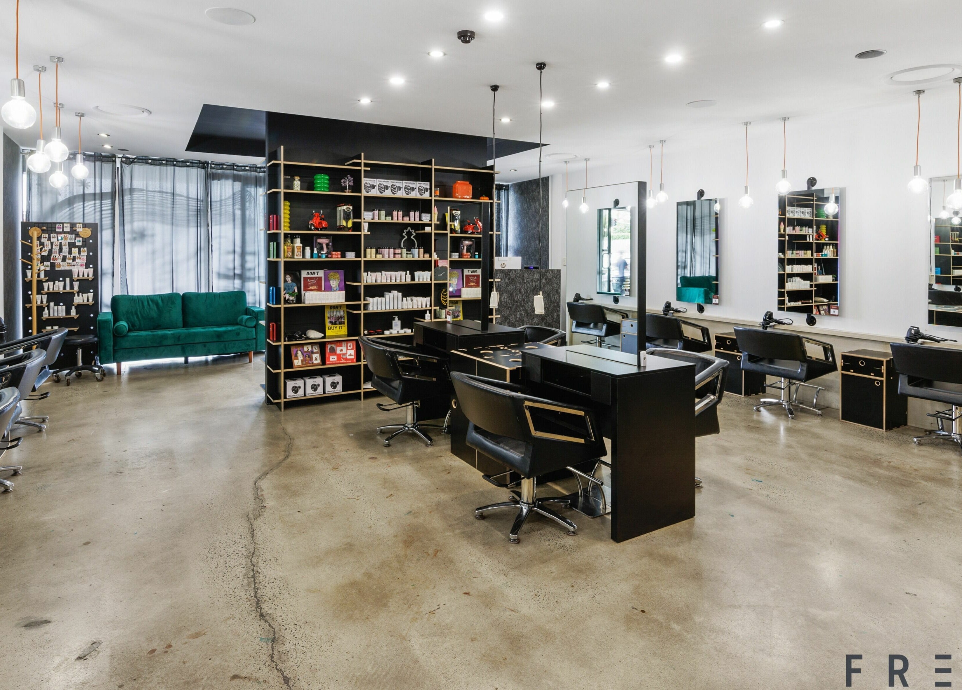 Modern salon interior of Lunatic Fringe in Clayfield, Queensland, AU with sleek styling stations and vibrant decor.