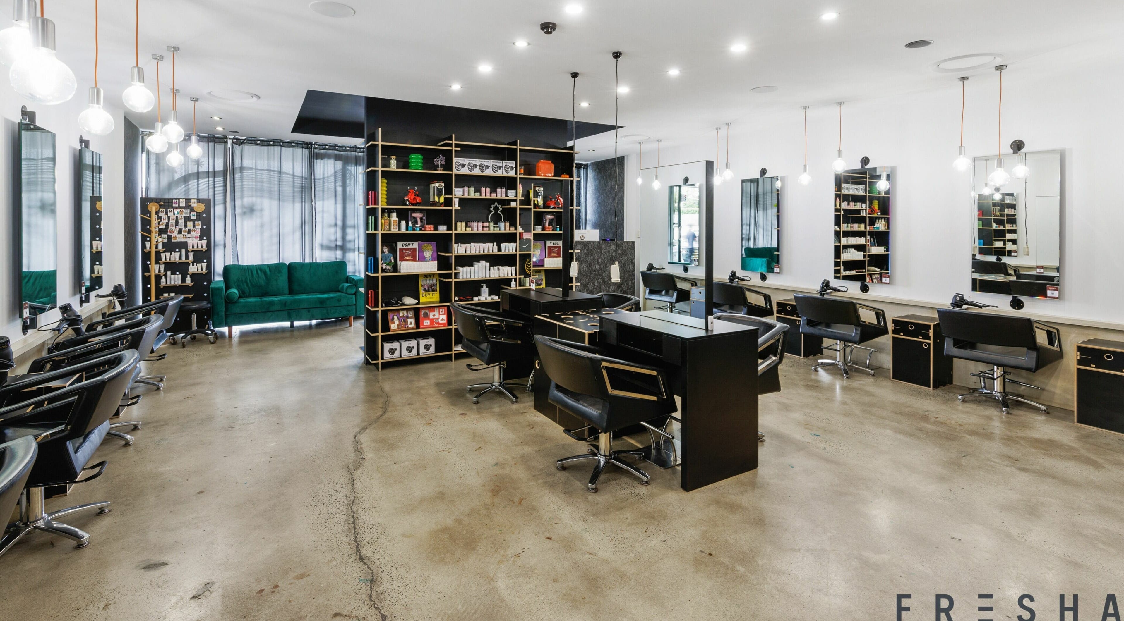 Modern salon interior of Lunatic Fringe in Clayfield, Queensland, AU with sleek styling stations and vibrant decor.