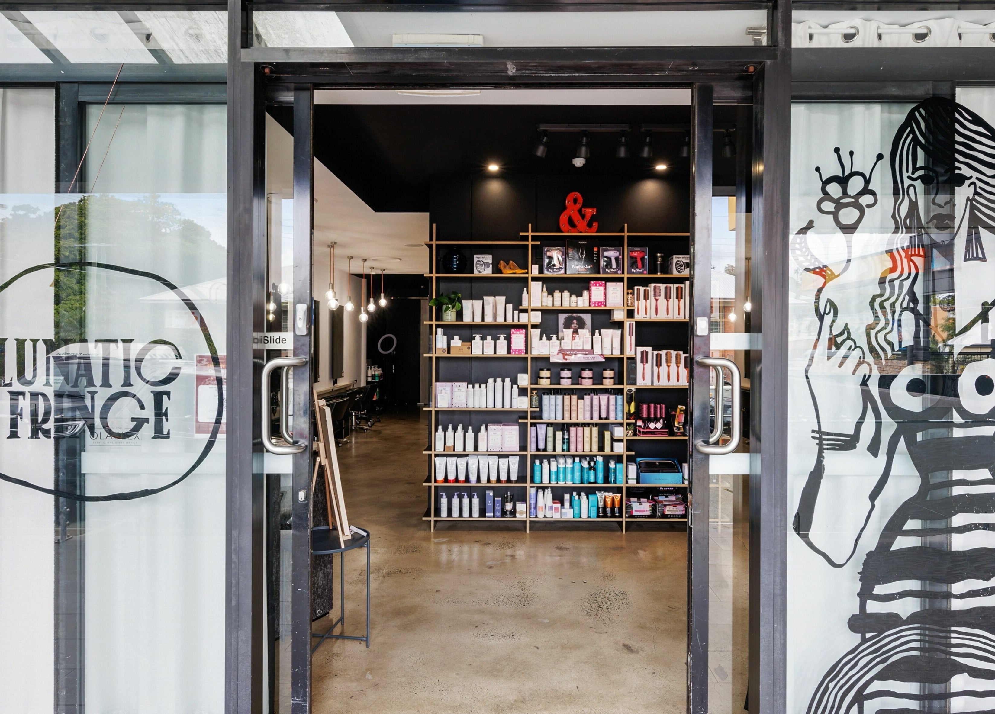 Entrance to Lunatic Fringe salon in Clayfield, Queensland, AU, featuring sleek interior and chic design.