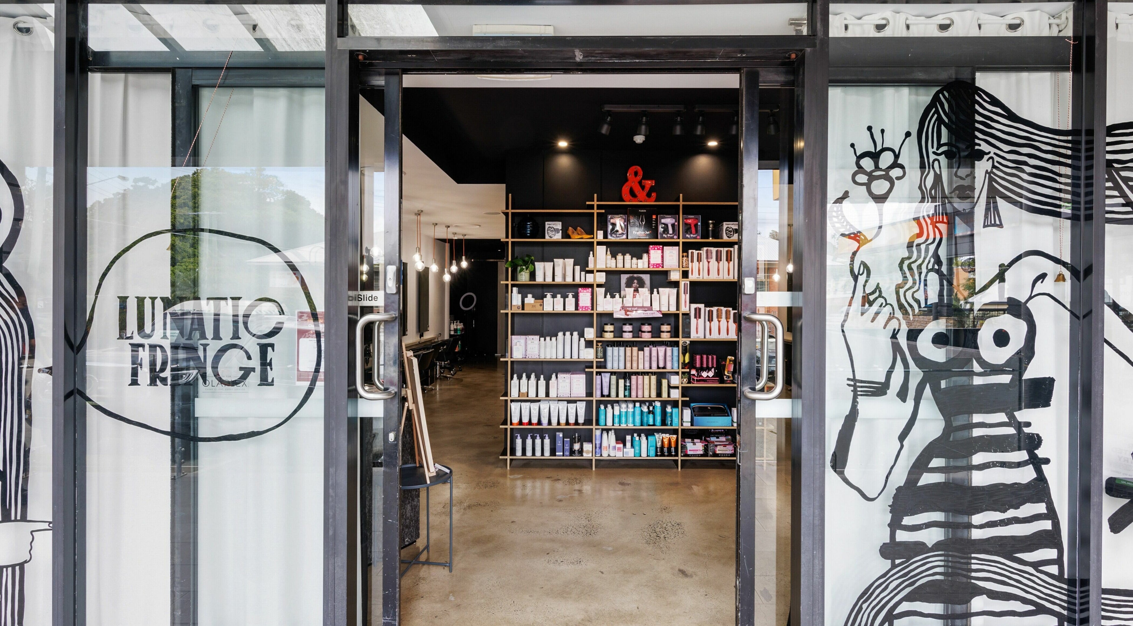 Entrance to Lunatic Fringe salon in Clayfield, Queensland, AU, featuring sleek interior and chic design.