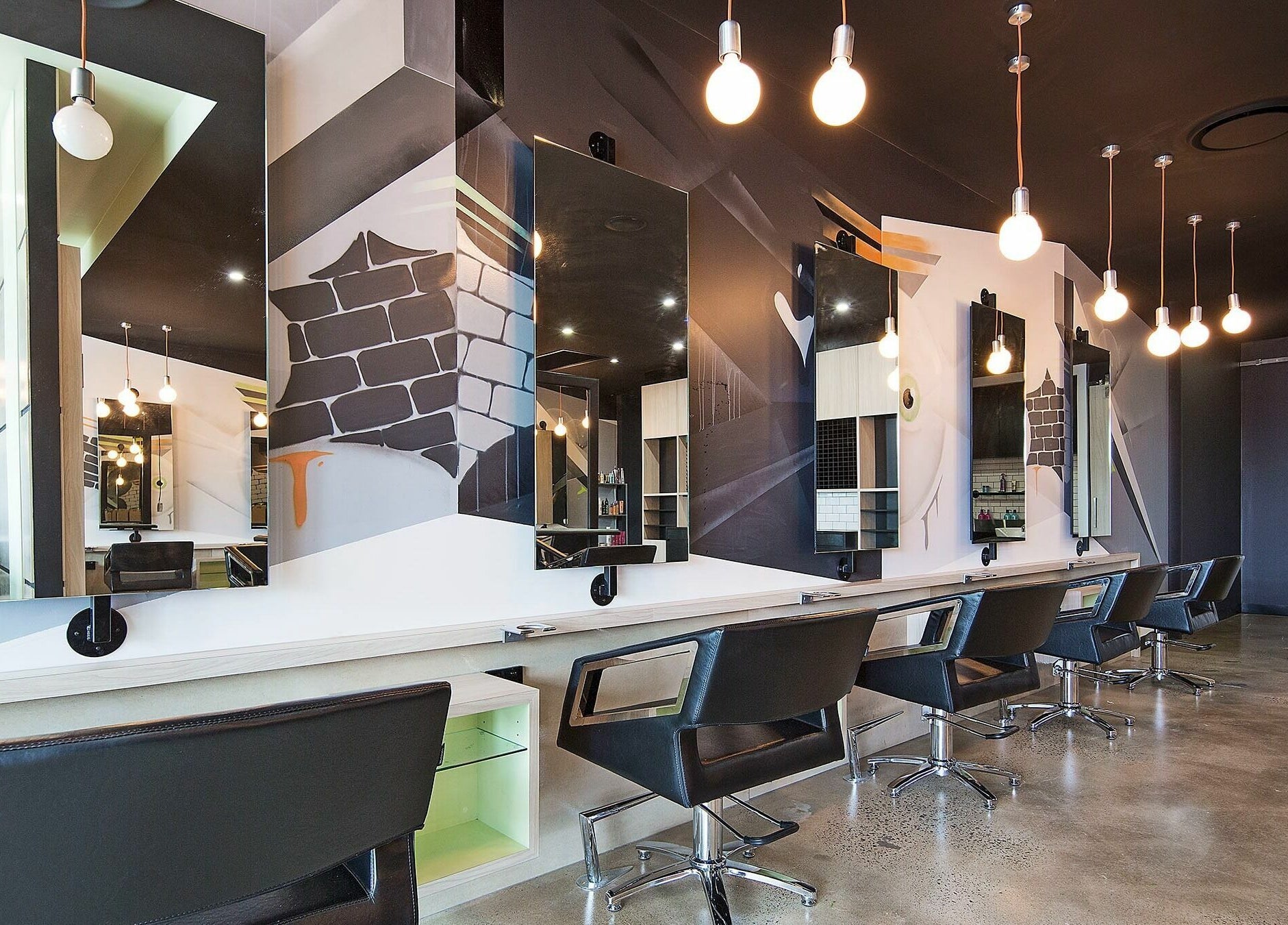 Modern salon interior of Lunatic Fringe in Clayfield, Queensland, AU with stylish chairs and artistic mirrors.