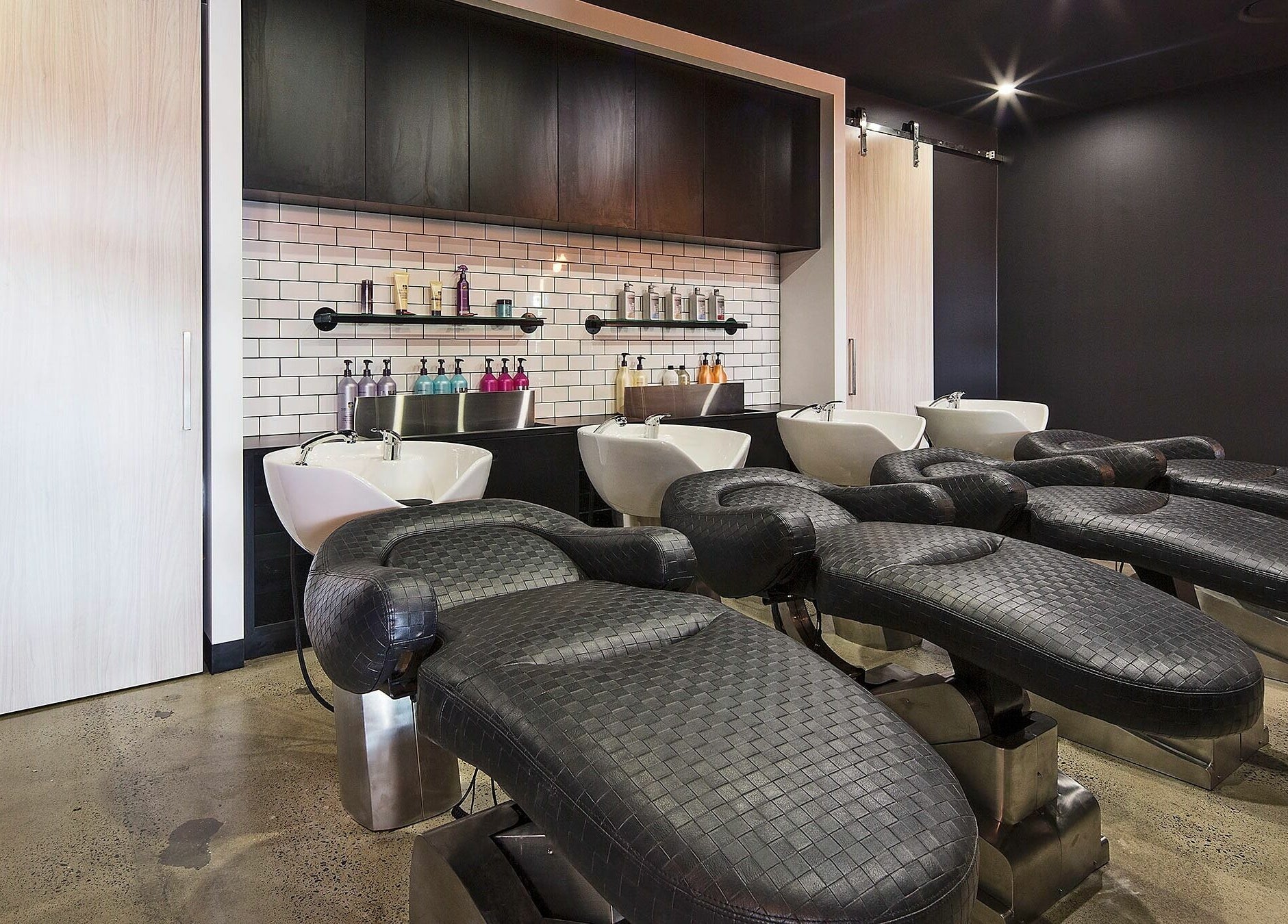 Modern salon wash stations at Lunatic Fringe, Clayfield, Queensland, AU, showcasing sleek design and comfort.