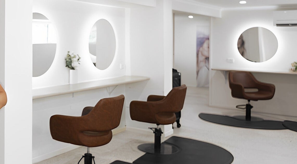 Stylish interior of Vanity Hair Lounge, Bundamba, Queensland, AU, featuring modern salon chairs and elegant mirrors.