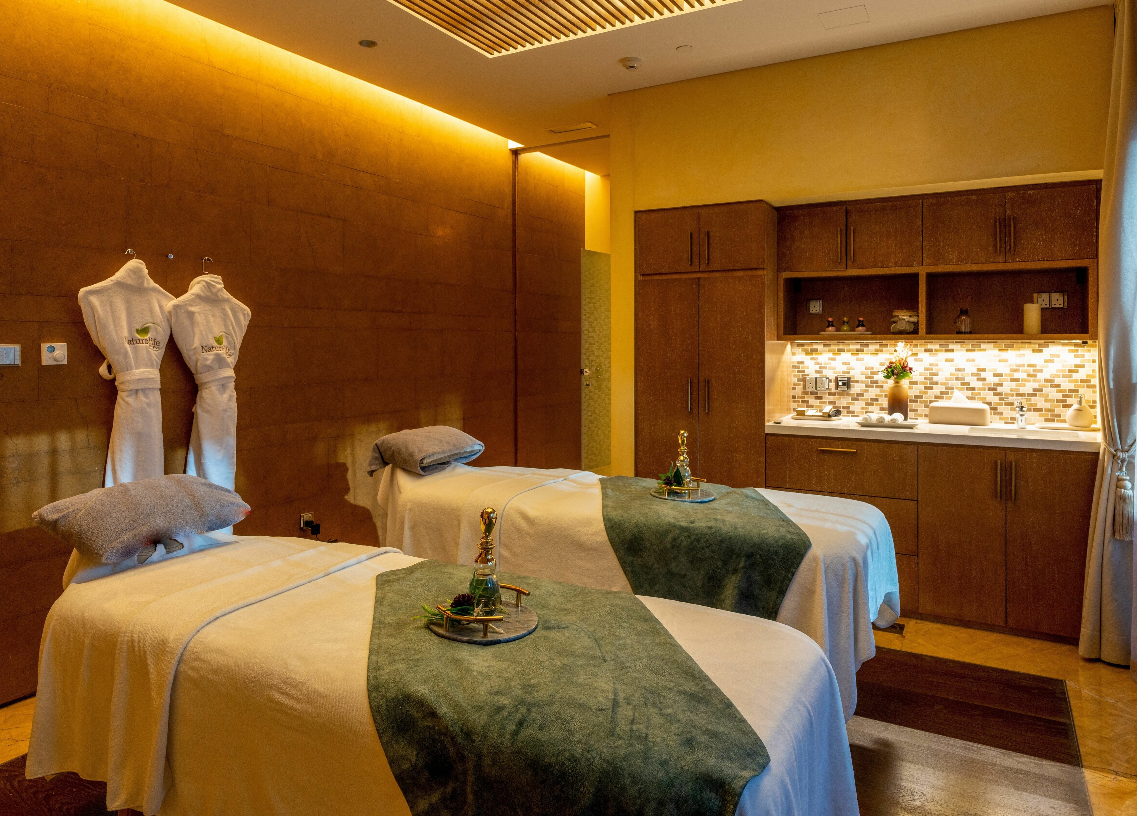Relaxing treatment room at Naturelife Spa Rixos Marina Abu Dhabi, featuring twin massage tables. Abu Dhabi, AE.